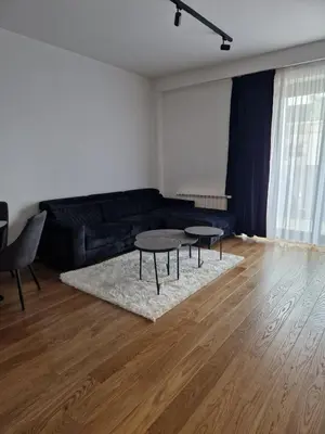 a living room with a black couch and a table at TOMAS LUX APARTMENTS in Banja Luka