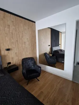 a bedroom with a mirror and a chair and a bed at TOMAS LUX APARTMENTS in Banja Luka