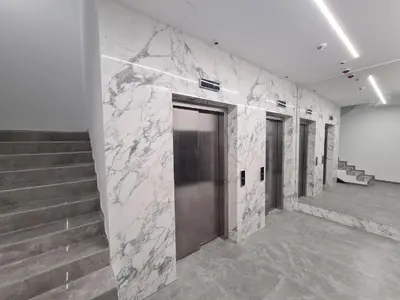 a lobby with stairs and a door with a marble wall at TOMAS LUX APARTMENTS in Banja Luka