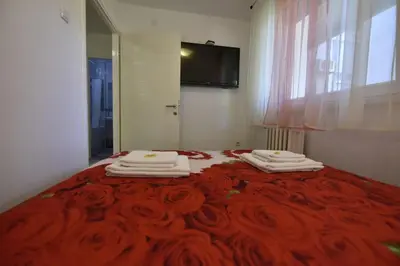 a bedroom with a red bed with towels on it at Apartman Isidora in Banja Luka