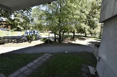 a park with trees and blue parking meters at Apartman Isidora in Banja Luka