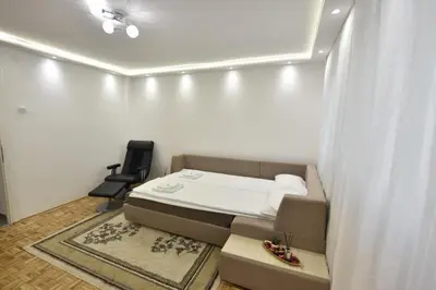 a small bedroom with a bed and a chair at Apartman Isidora in Banja Luka
