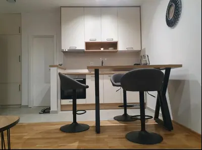 a kitchen with a wooden table and two chairs at ApartmanM&M in Banja Luka