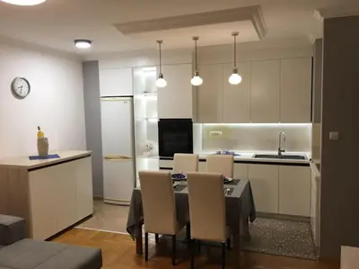 a kitchen with a table and chairs in a room at Apartman DeLUX in Banja Luka