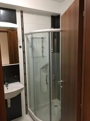 a bathroom with a glass shower and a sink at Apartman DeLUX in Banja Luka