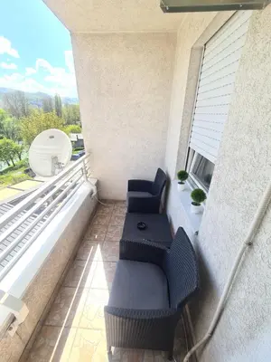 a balcony with two blue chairs and a window at Apartman Mirjana in Banja Luka