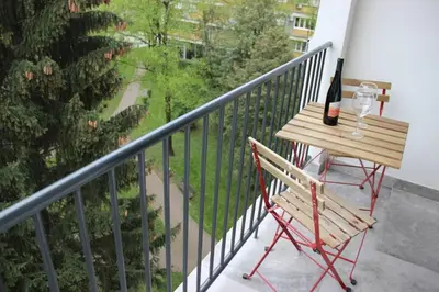 a table with a bottle of wine and a wine glass on a balcony at Green Oasis in Banja Luka
