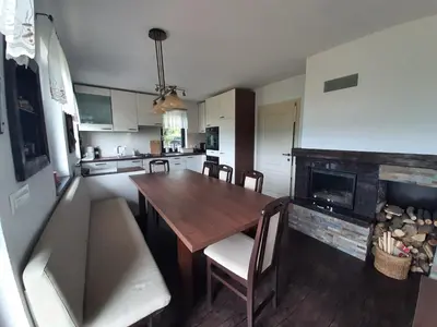 a kitchen with a wooden table and a fireplace at House Na Starom Kućištu in Todorovo