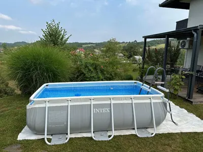 a large tub sitting in the grass next to a house at House Na Starom Kućištu in Todorovo
