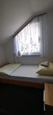 a small room with a window with a white curtain at Apartments Mario in Drvar