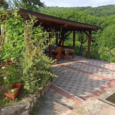 a pavilion with a picnic table and a bench at Guest House Bee in Visoko