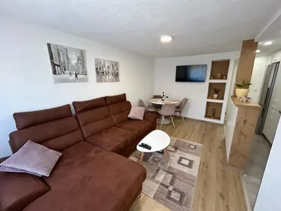 a living room with a brown couch and a table at Brand new apartment in Banja Luka