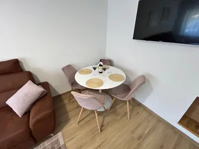 a living room with a table and chairs and a couch at Brand new apartment in Banja Luka