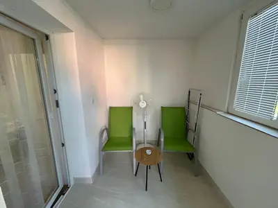 two green chairs and a table in a room at Brand new apartment in Banja Luka