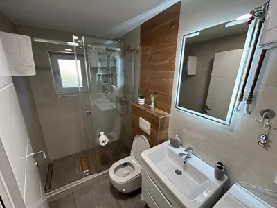 a bathroom with a toilet and a sink and a shower at Brand new apartment in Banja Luka