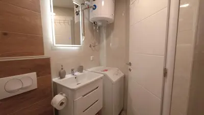 a white bathroom with a sink and a mirror at Brand new apartment in Banja Luka
