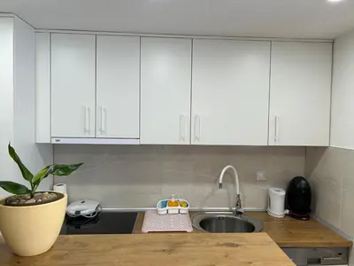 a kitchen with white cabinets and a sink at Brand new apartment in Banja Luka