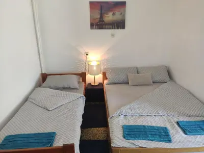 two twin beds in a room with a lamp at Apartmani Nova Topola in Nova Topola