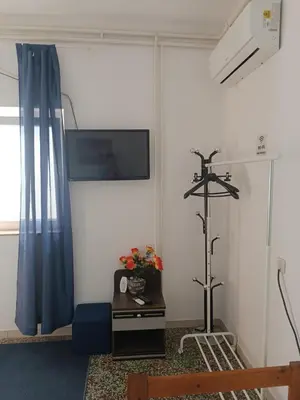 a living room with a tv and a blue curtain at Apartmani Nova Topola in Nova Topola