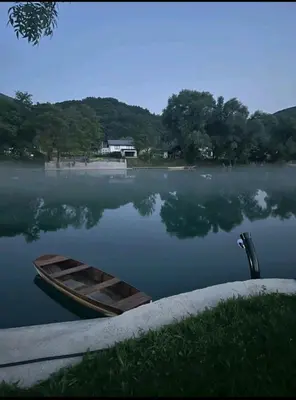a wooden boat sitting on the water in a lake at House De Luxe in Bihać