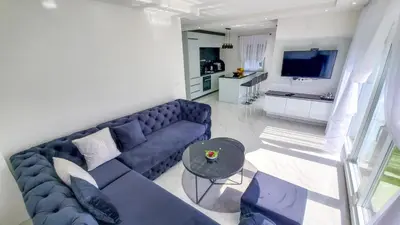 a living room with a blue couch and a table at House De Luxe in Bihać
