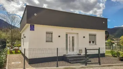 a small white house with a black roof at House De Luxe in Bihać