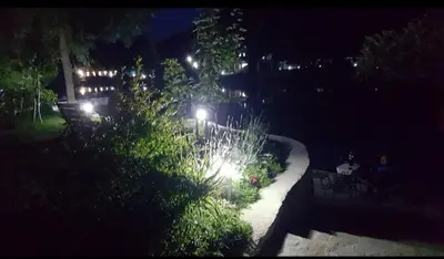 a garden at night with lights in a yard at House De Luxe in Bihać