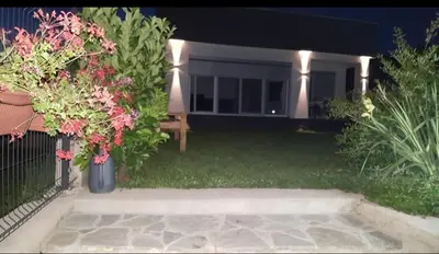 a backyard at night with flowers and a fence at House De Luxe in Bihać