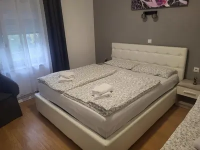 a white bed with two towels on top of it at Apartman D&D 1 in Jajce