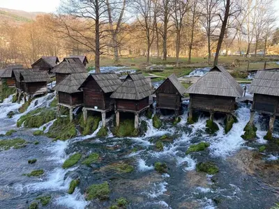 a group of wooden huts on a river at Apartman D&D 1 in Jajce