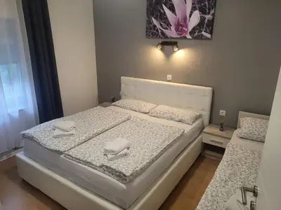 a bedroom with a white bed with two napkins on it at Apartman D&D 1 in Jajce