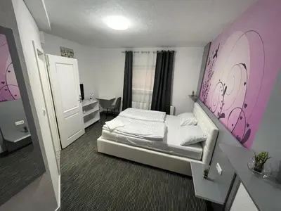 a bedroom with a bed with a pink wall at Apartman D&D 2 in Jajce