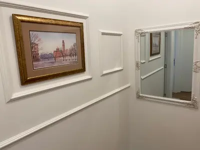 a painting on a wall next to a mirror at Zeus Apartment in Banja Luka