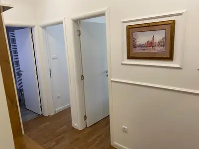 a hallway with two doors and a painting on the wall at Zeus Apartment in Banja Luka