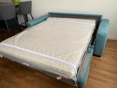 a bed in a room with a blue frame at Zeus Apartment in Banja Luka