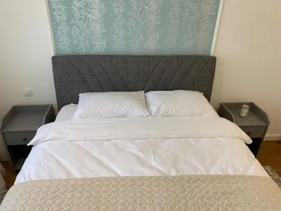 a bedroom with a bed with two nightstands next to it at Zeus Apartment in Banja Luka