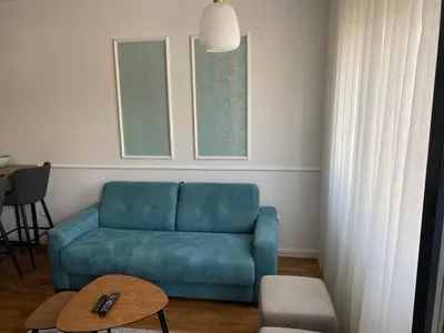 a living room with a blue couch and a table at Zeus Apartment in Banja Luka
