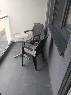 two chairs and a table in a room with a window at Apartman Vista Banja Luka in Banja Luka