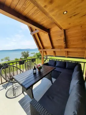 a patio with a table and a couch on a deck at Lake House Beliz in Livno