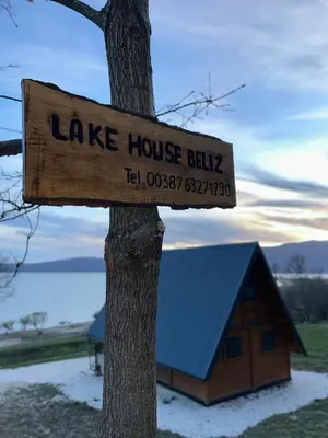 a sign on a tree in front of a house building at Lake House Beliz in Livno