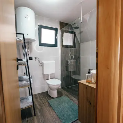 a bathroom with a toilet and a glass shower at Lake House Beliz in Livno