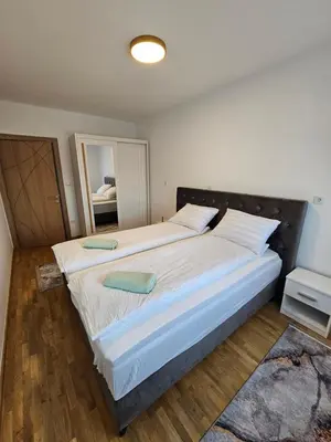 a large bed with two pillows on it in a bedroom at Sara Apartments in Visoko