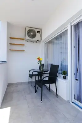 a dining room with a table and chairs and a fan at Sara Apartments in Visoko