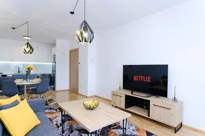 a living room with a tv and a couch and a table at Sara Apartments in Visoko
