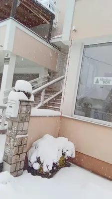 a fire hydrant covered in snow in front of a house at Apartman Bor in Livno