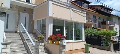 a building with stairs and flowers in front of it at Apartman Bor in Livno