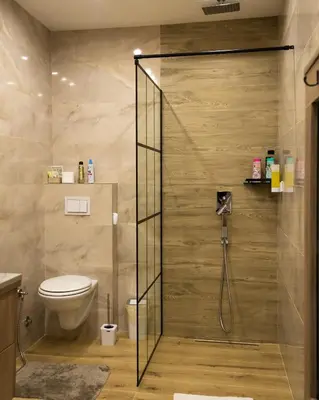 a bathroom with a toilet and a glass shower stall at Ema, Asja, Eda Apartments in Zenica