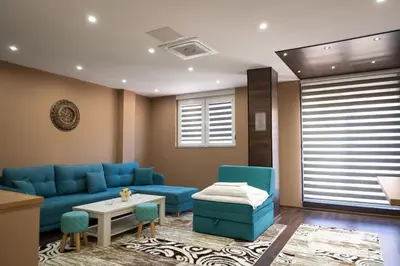 a living room with a blue couch and a table at Ema, Asja, Eda Apartments in Zenica