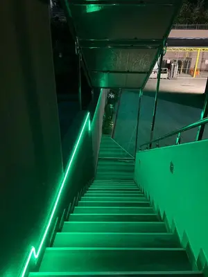 a staircase with green lights on the side of a building at Ema, Asja, Eda Apartments in Zenica