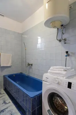 a bathroom with a washing machine and a tub at The Cosmic Gate Apartments in Visoko